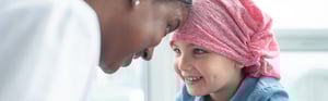 Nurse with a little girl cancer patient smiling