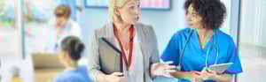 Medical Admin and a nurse walking and talking in a hospital setting